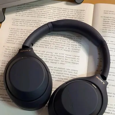 A pair of black over-ear headphones resting on an open book